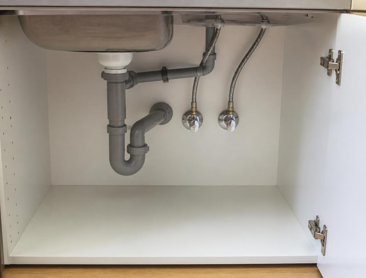 A finished, tidy under-sink plumbing repair with new shutoff valves